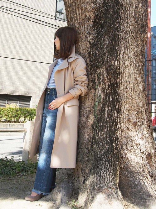 丈が長めのハンサムスタイルのトレンチコート。襟を立てて手首をしっかり出せば、こなれ感のある大人びた印象に。